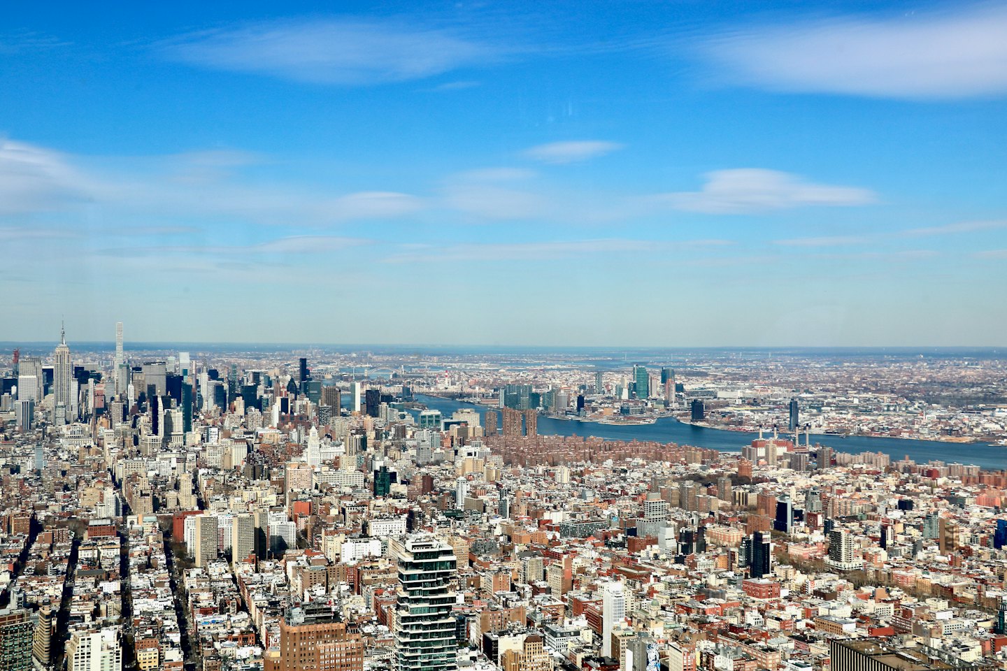A wide river flows through a dense urban city landscape.